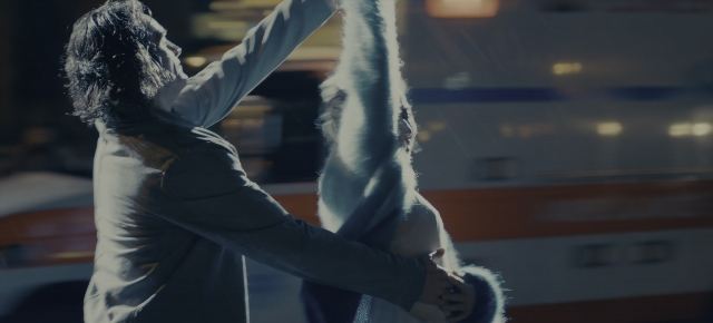 Wide shot frame from Joker: Folie à Deux — standing, room, suit