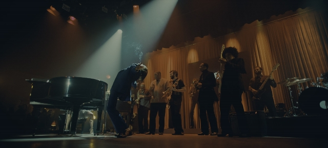 Wide shot frame from Joker: Folie à Deux — suit, drum, person