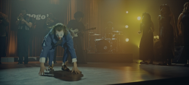 Wide shot frame from Joker: Folie à Deux — standing, suit, drum