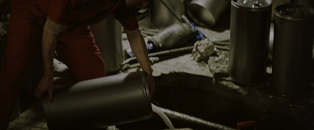 Wide shot frame from Batman Begins — room, face, person