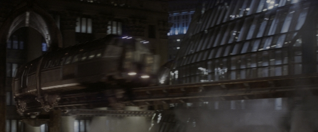 Wide shot frame from Batman Begins — night, water, train
