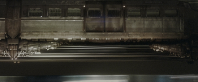 Wide shot frame from Batman Begins — night, train