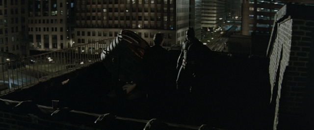 Wide shot frame from Batman Begins — standing, street, night