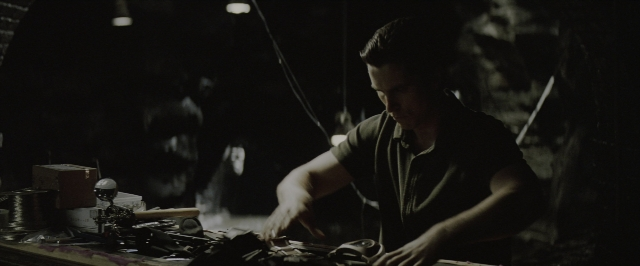 Wide shot frame from Batman Begins — sitting, shirt, person
