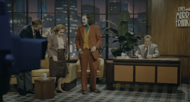 Wide shot frame from Joker — sitting, standing, room
