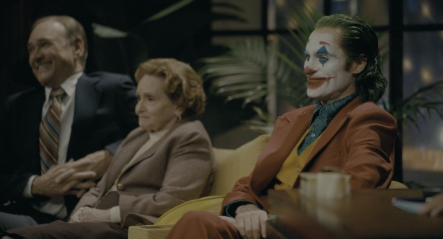Wide shot frame from Joker — sitting, room, table