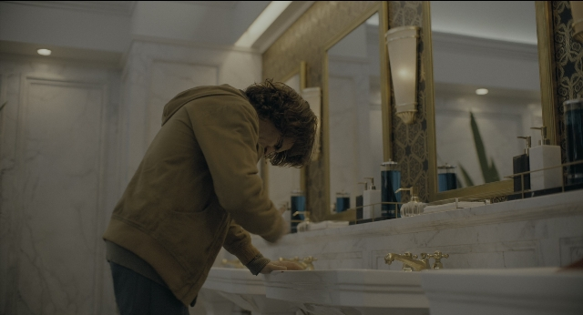 Wide shot frame from Joker — standing, room, mirror