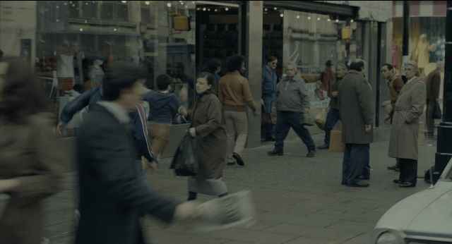 Medium shot frame from Joker — walking, street, car