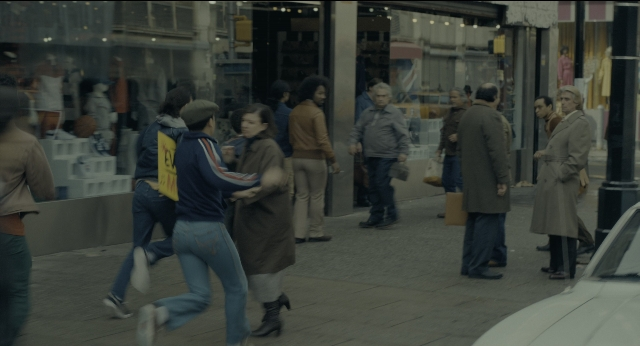 Wide shot frame from Joker — walking, street, fight