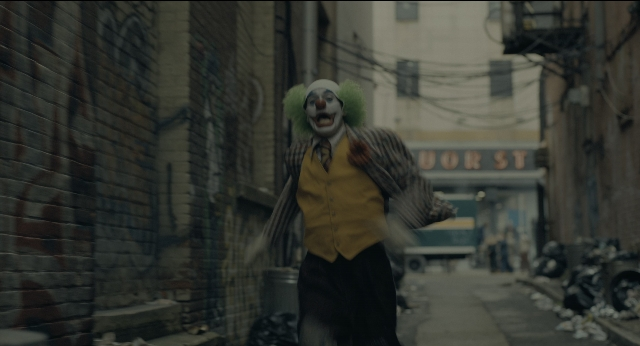 Wide shot frame from Joker — walking, street, hat