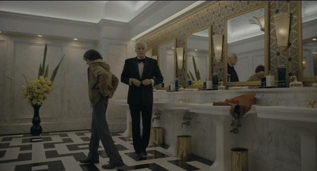 Wide shot frame from Joker — standing, room, phone