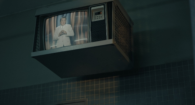 Wide shot frame from Joker — suit, tie, face