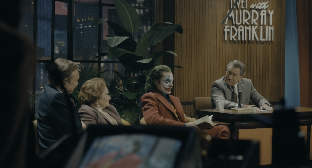 Wide shot frame from Joker — sitting, room, table