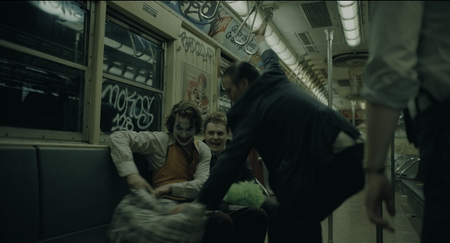 Wide shot frame from Joker — hand, shirt, face
