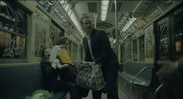 Wide shot frame from Joker — sitting, standing, door