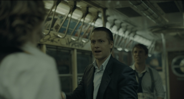 Wide shot frame from Joker — standing, suit, face