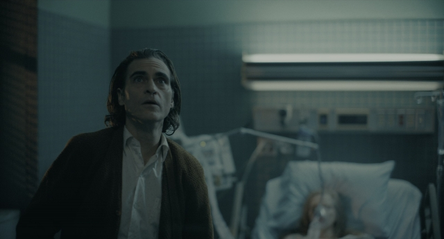 Wide shot frame from Joker — standing, room, bed