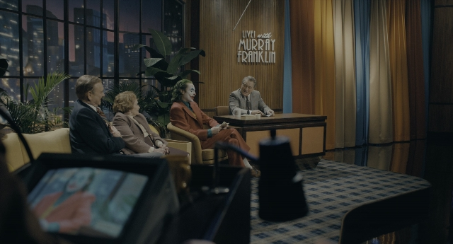 Wide shot frame from Joker — sitting, room, table