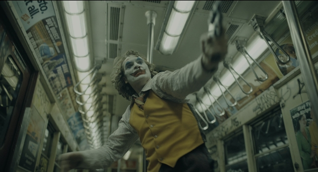 Wide shot frame from Joker — standing, hand, gun