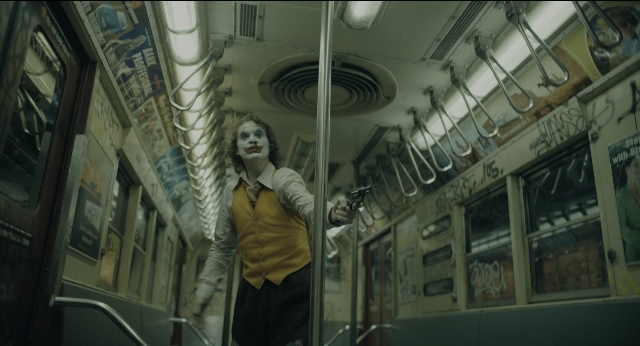 Wide shot frame from Joker — standing, hand, shirt