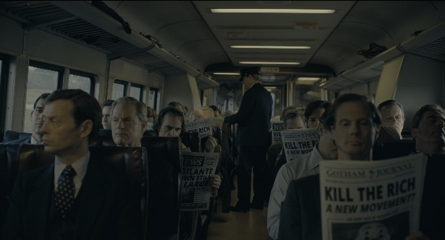 Wide shot frame from Joker — sitting, dialogue, suit
