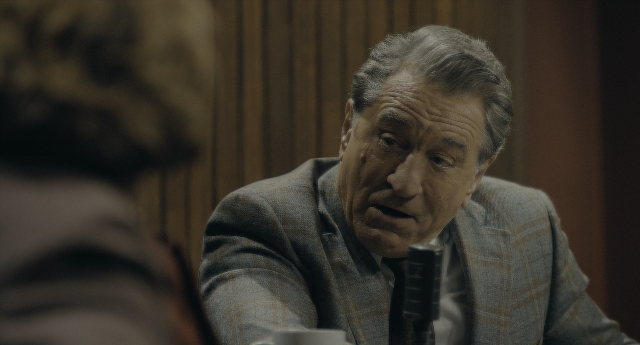 Wide shot frame from Joker — sitting, room, table
