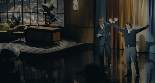 Wide shot frame from Joker — standing, table, chair
