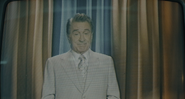 Wide shot frame from Joker — suit, tie, face