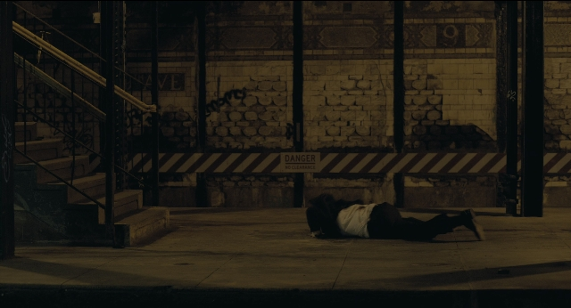 Wide shot frame from Joker — person, footwear, stairs