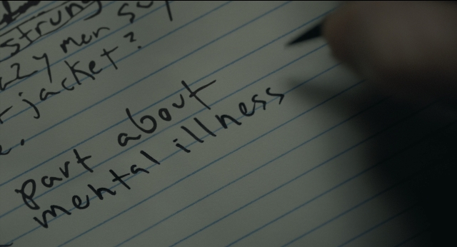 Wide shot frame from Joker — hand, person, office supplies