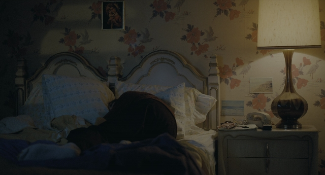 Wide shot frame from Joker — room, bed, phone