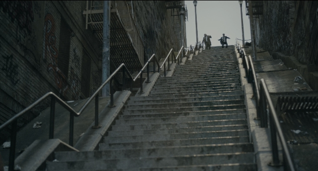 Wide shot frame from Joker — walking, person, building