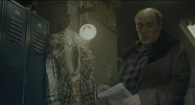 Wide shot frame from Joker — standing, room, coat