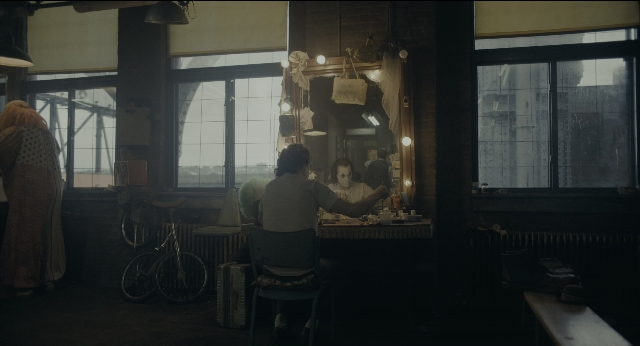 Wide shot frame from Joker — sitting, standing, room