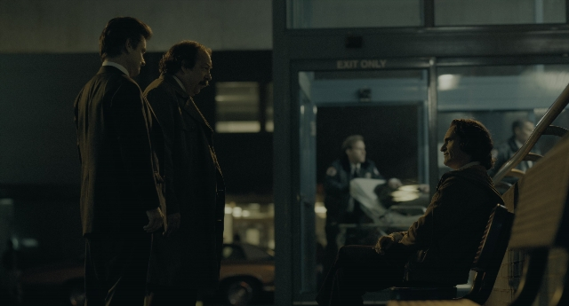 Wide shot frame from Joker — sitting, standing, dialogue