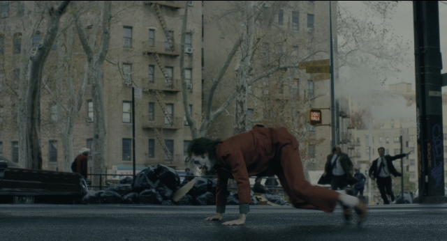 Wide shot frame from Joker — walking, street, suit