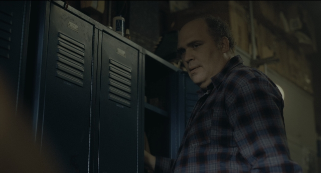 Wide shot frame from Joker — standing, shirt, face