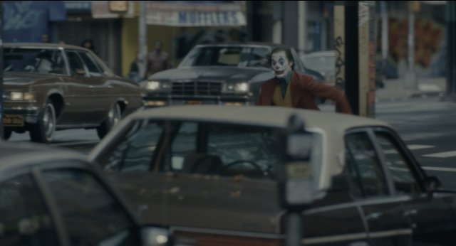 Wide shot frame from Joker — standing, walking, street