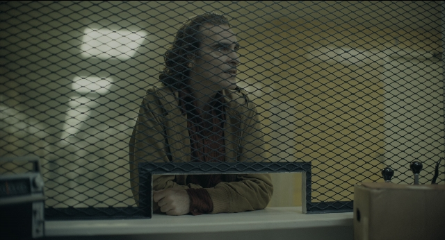 Medium shot frame from Joker — sitting, room, table