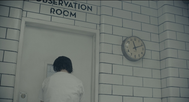 Wide shot frame from Joker — standing, room, door