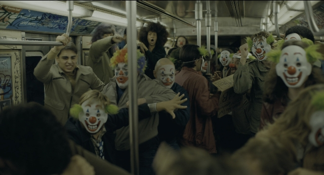 Wide shot frame from Joker — standing, hair, train