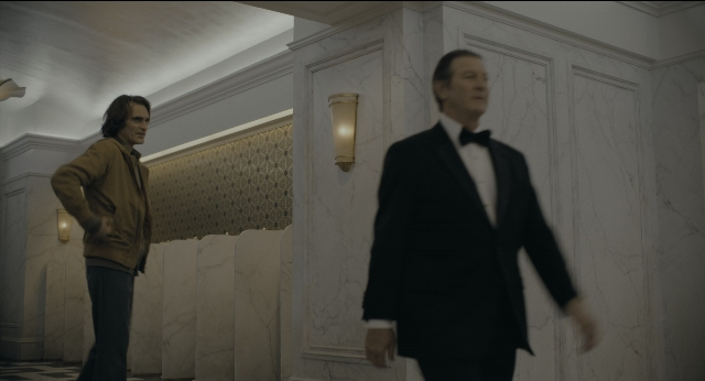 Wide shot frame from Joker — walking, room, hand