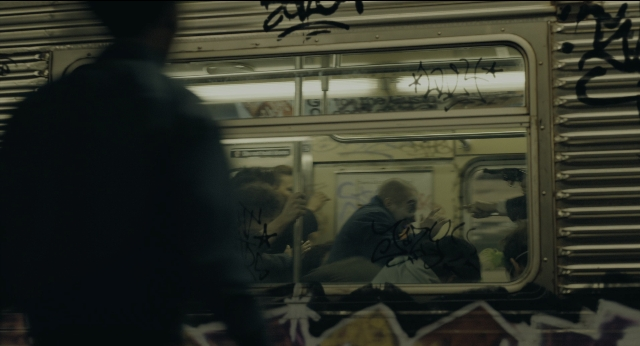 Wide shot frame from Joker — sitting, train, person