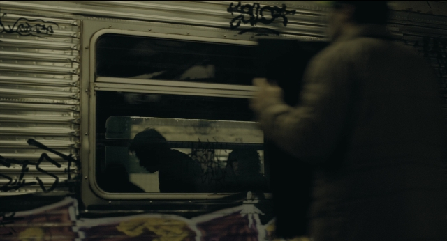 Wide shot frame from Joker — standing, car, train