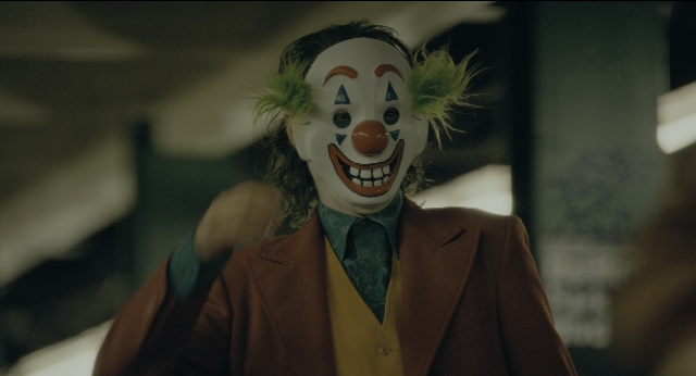 Wide shot frame from Joker — suit, tie, face