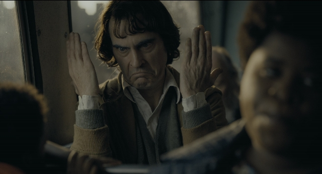 Wide shot frame from Joker — sitting, face, hair