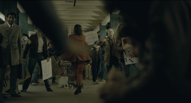 Wide shot frame from Joker — walking, street, coat