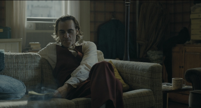 Wide shot frame from Joker — sitting, room, table