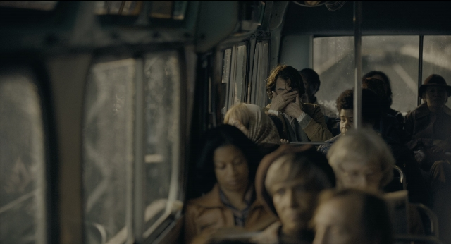 Wide shot frame from Joker — sitting, suit, tie