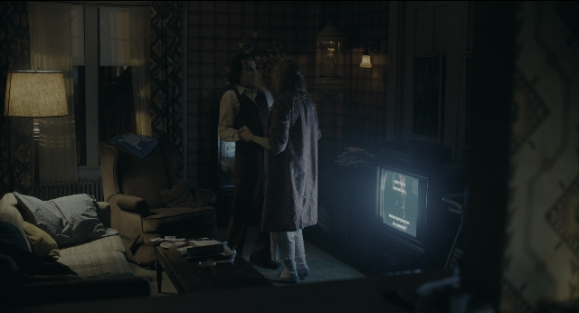 Wide shot frame from Joker — standing, room, table